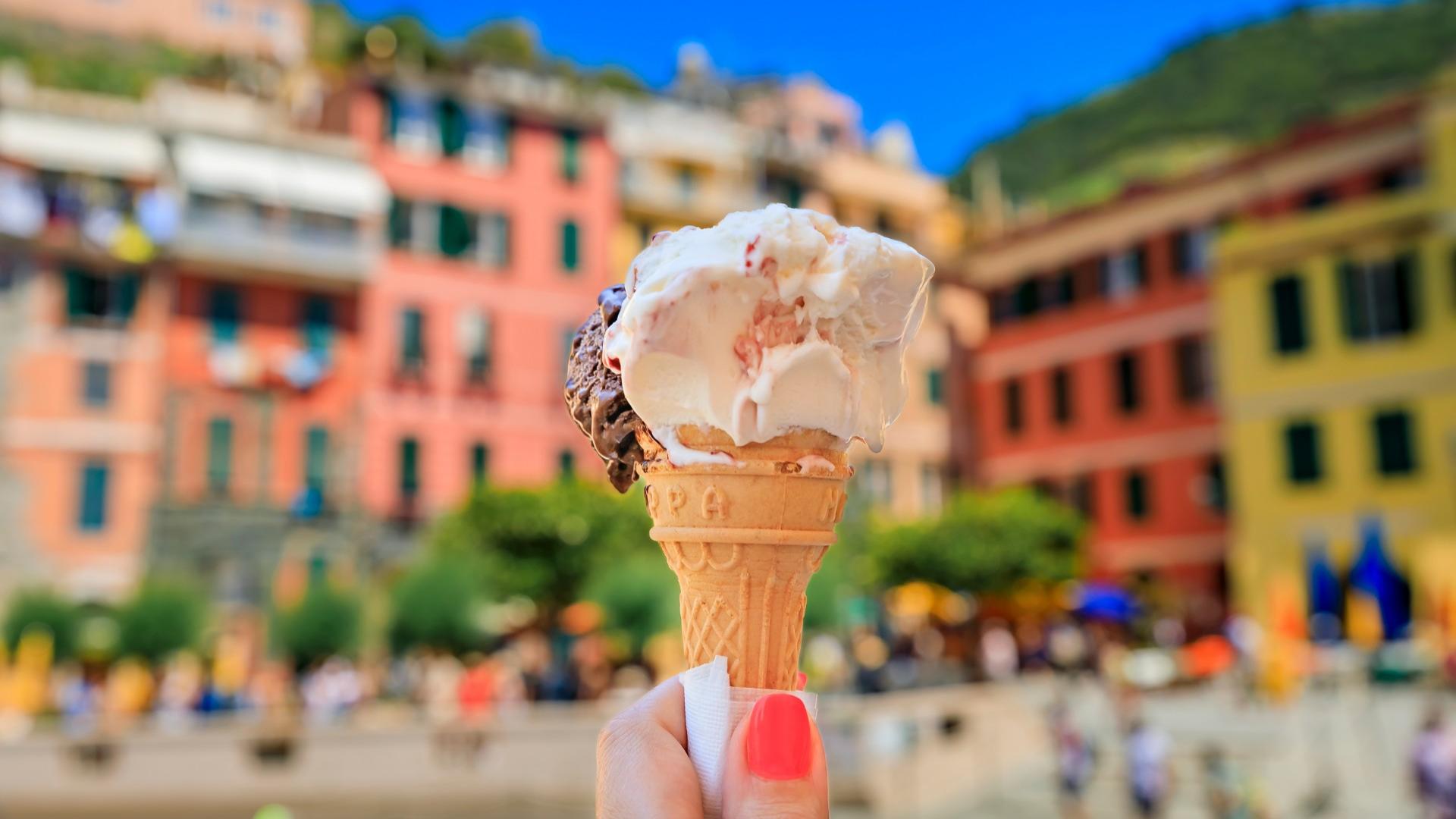 Eiscreme im Vordergrund mit bunten Häusern im Hintergrund.