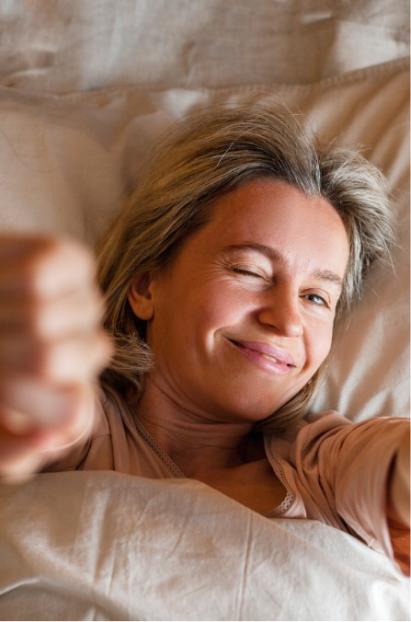 Smiling person winking while in bed.