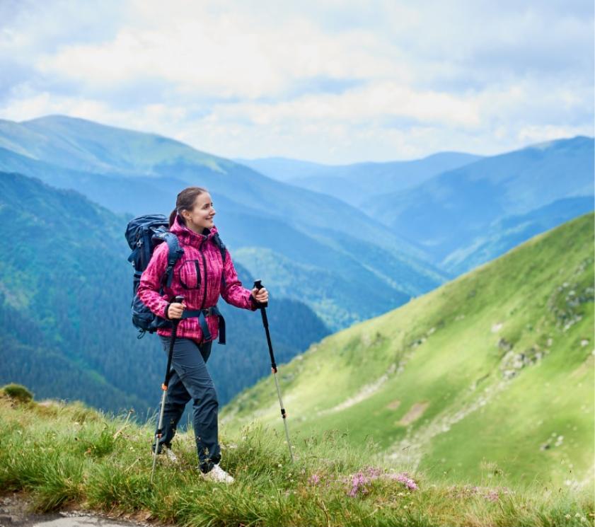 Randonneur en montagne avec bâtons de trekking et sac à dos.